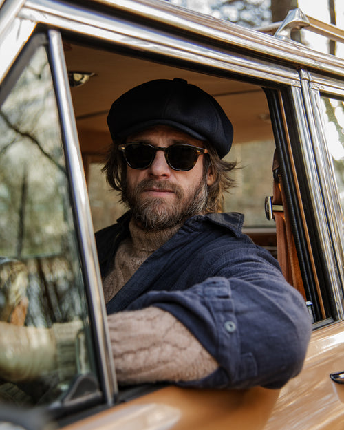 A woman placing a contact lens on her eye with one finger.