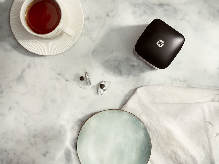 A machine cuts a glasses frame while water splashes around.