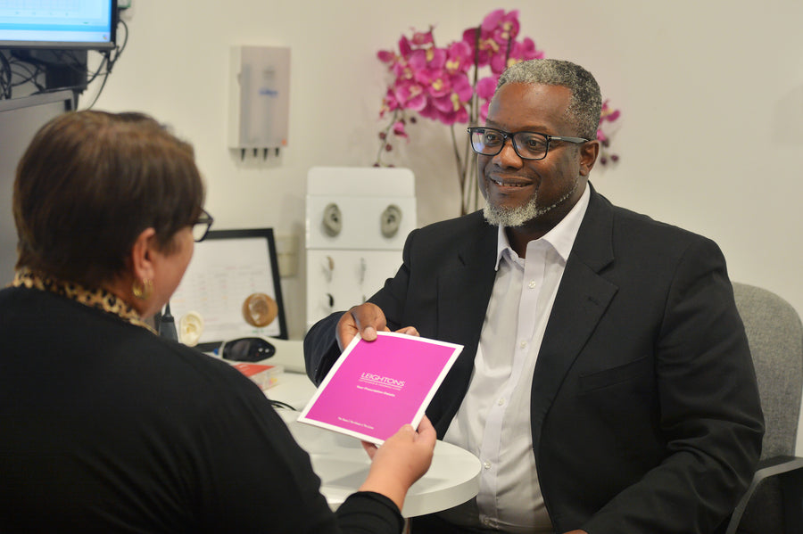 Stylish sunglasses resting on a green tray against a textured background.