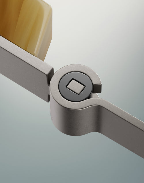 A woman in gloves operates a machine with metal pieces nearby.