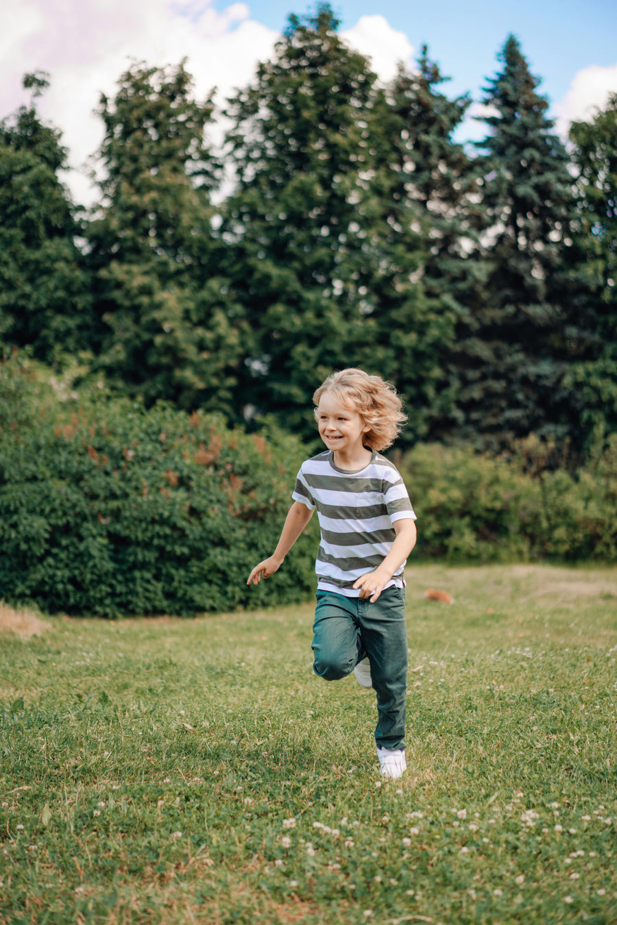 boy with long hair running outside