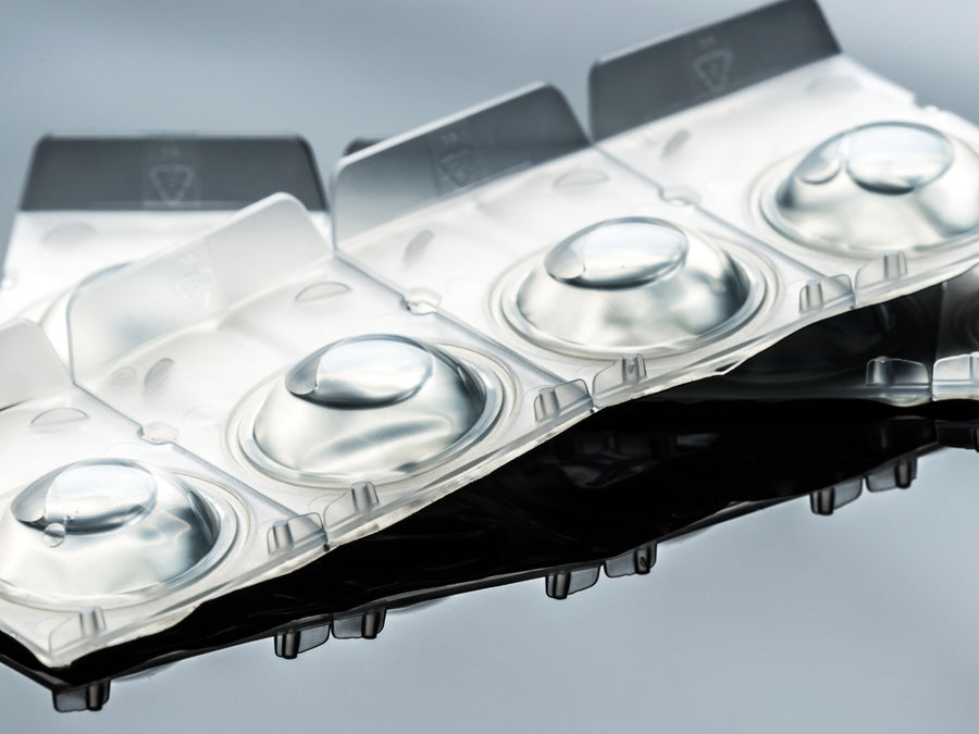 Close-up of empty transparent blister pack for medication on reflective surface.