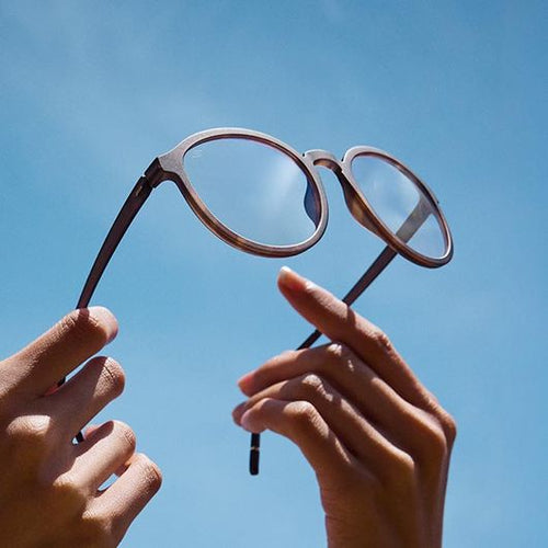 A man holds a mirror while a woman shows him his reflection.
