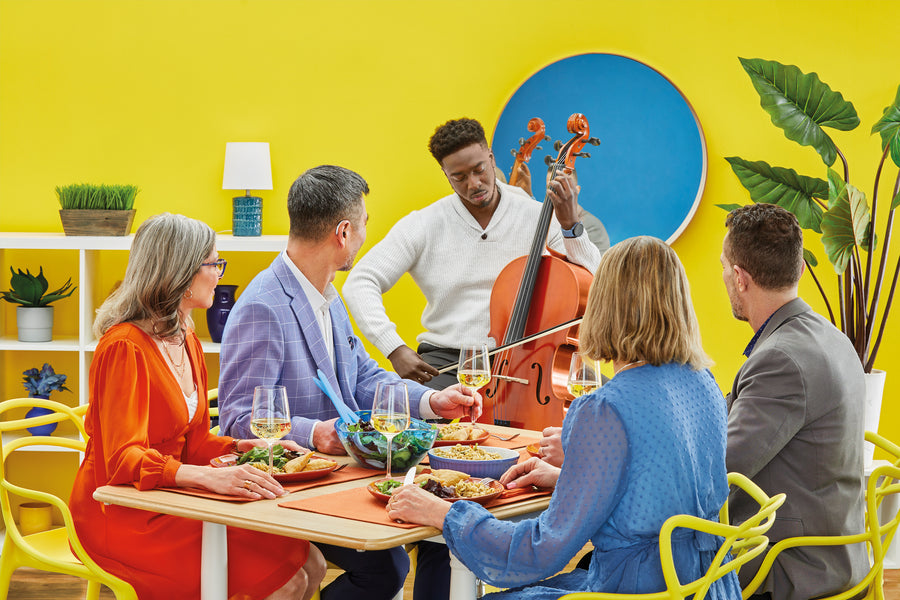 A joyful girl wearing floral pajamas jumps on a bed.
