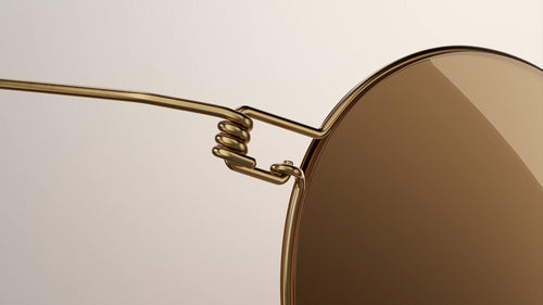 A smiling young man in glasses sitting next to a bicycle.