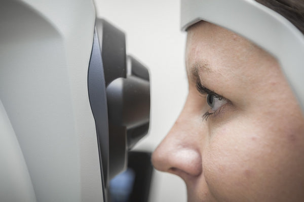 Close-up of an eye undergoing a vision test using an ophthalmic diagnostic device in a clinical setting.