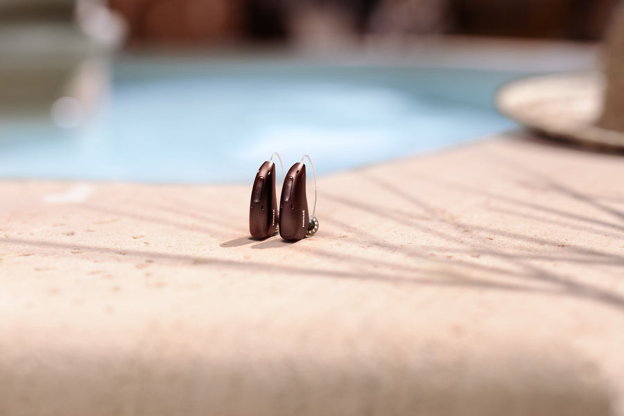 A woman shows a tablet to a man wearing headphones.