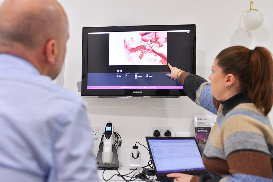 Two people looking at a computer screen displaying medical imaging.