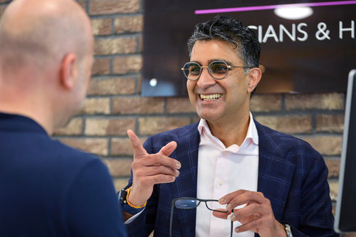 Woman with glasses and blonde hair wearing a black blazer.
