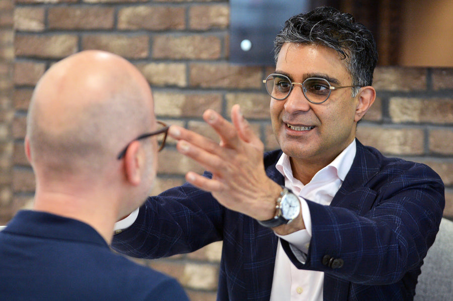 Two stylish tortoiseshell sunglasses floating over a pink background.