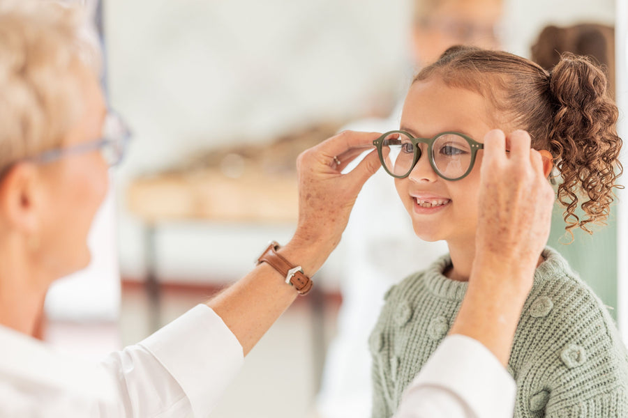 girl trying on new green glasses with dispensing optician
