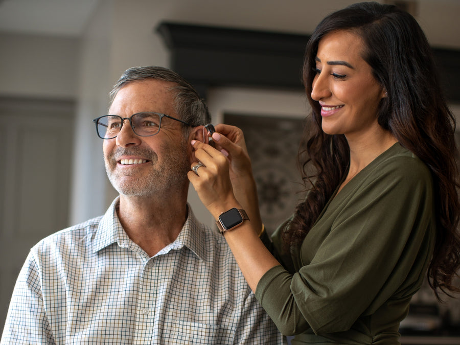 A woman in a black suit sits comfortably in a modern chair.