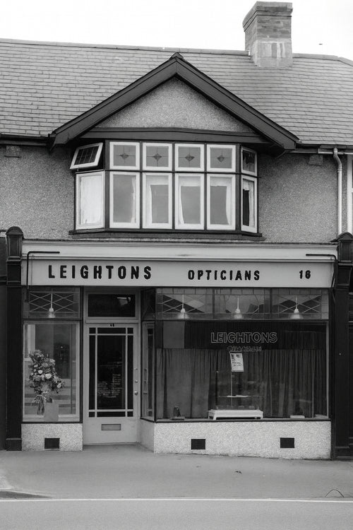 Black and white photo of Leightons Opticians store front.