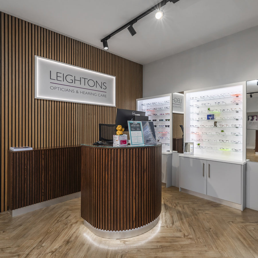 Optician's office with a reception desk and display cases.