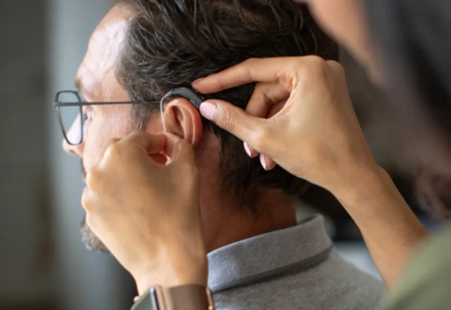 A woman with long hair wearing a blazer and sweater.