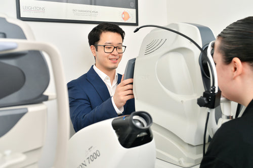 Person using a medical device with a technician assisting in a clinical setting