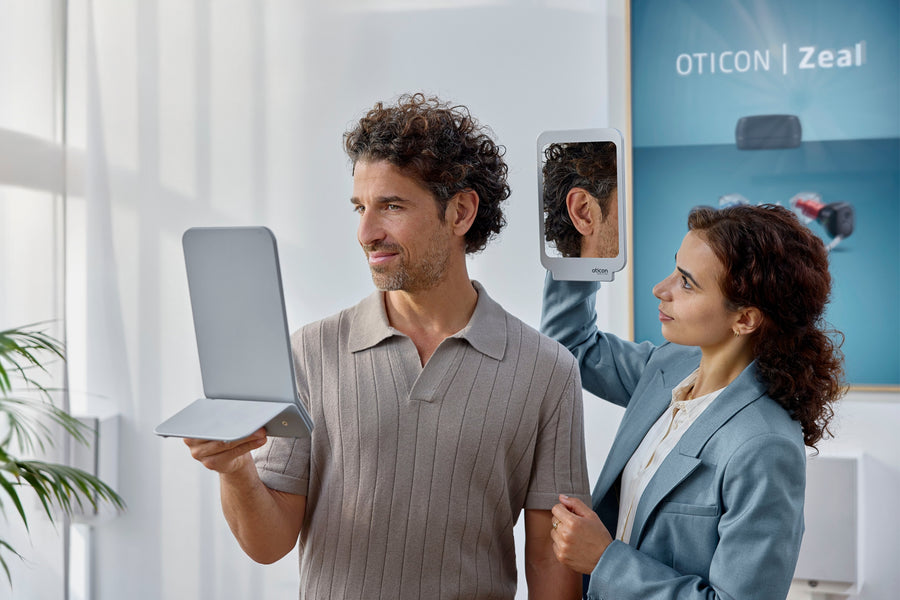 Close-up of a woman wearing round black glasses, showing her freckled skin.