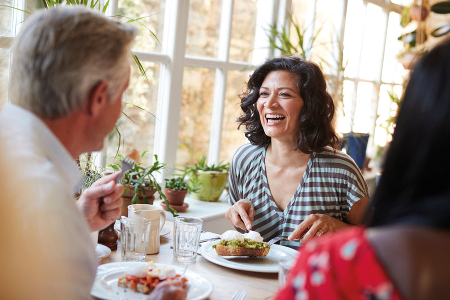 Tortoiseshell sunglasses resting on a log, reflecting a beach scene.