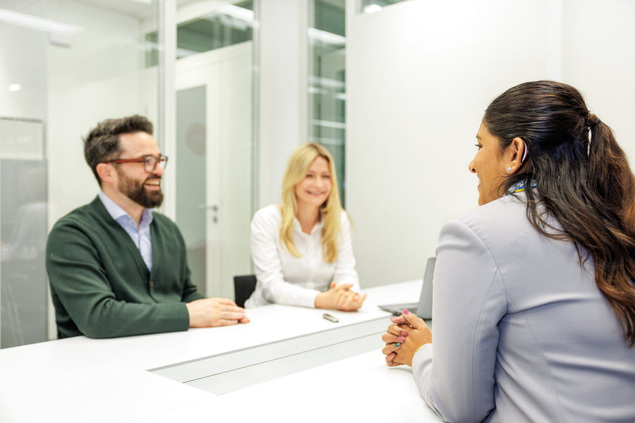Three people engaged in a product discussion at a meeting.