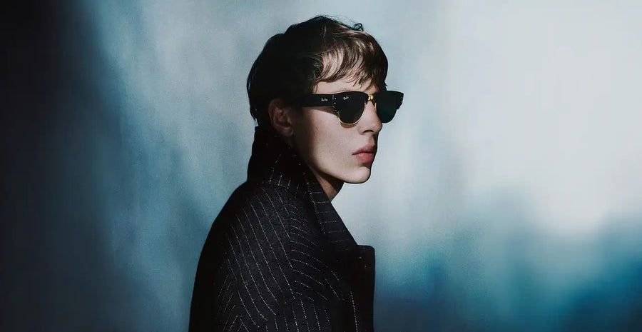 A woman wearing a yellow outfit stands by the ocean.