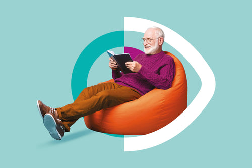 Man sitting on an orange bean bag chair reading a book against a teal background