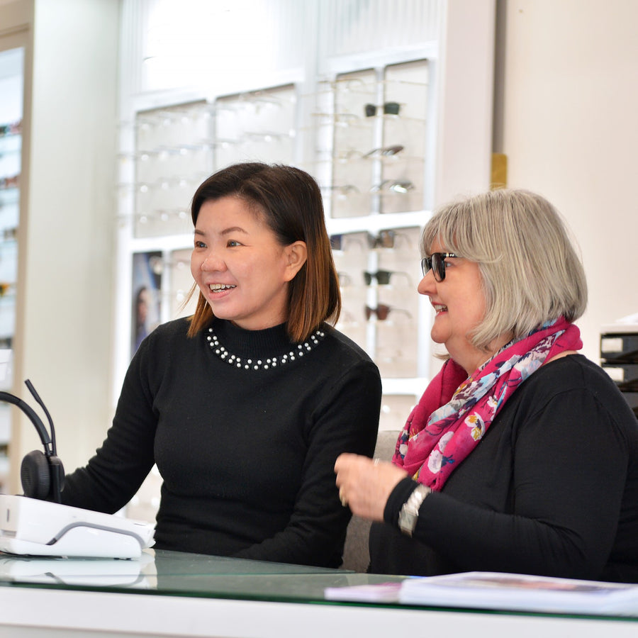 Two women sitting at a desk in an office setting