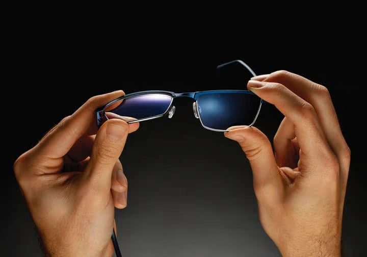 A man in sunglasses smiles while relaxing on a boat.