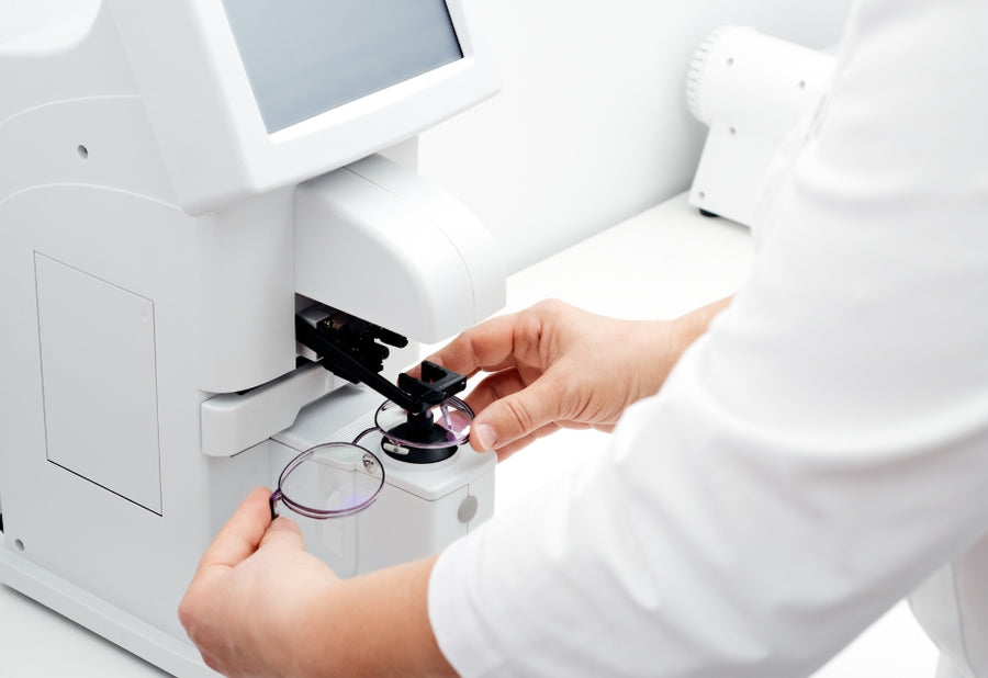A close-up of a model wearing round gold sunglasses, showcasing their features.